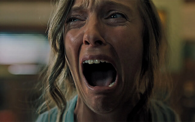 Mulher gritando com expressão de pavor em cena intensa do filme Hereditário.